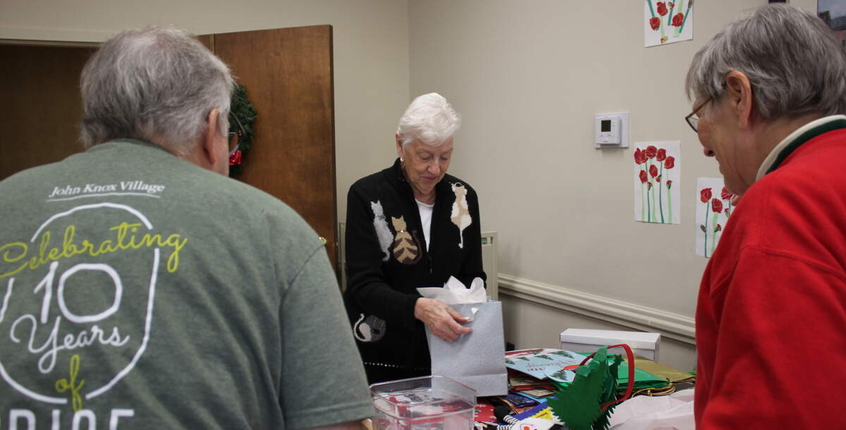 Sue Ridings helps shoppers at the John Knox Village Holiday Store on Dec. 6.