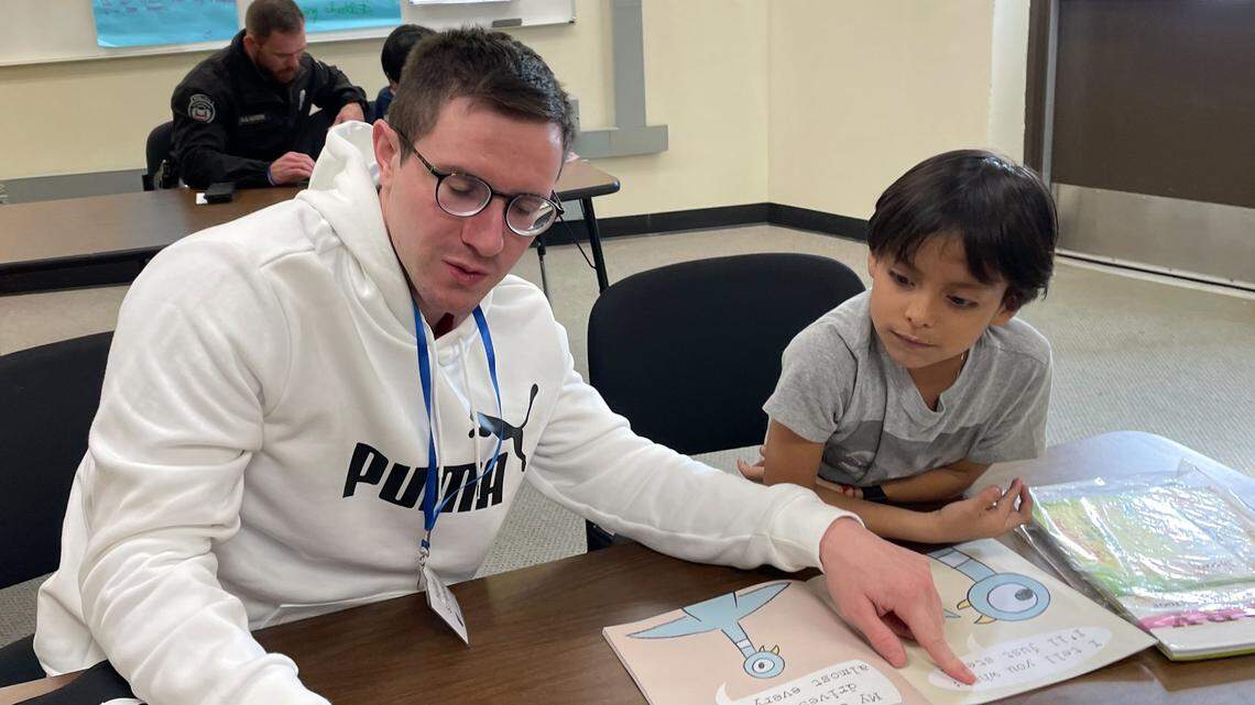 Hunter Simoncic, 26, left, is seen helping an elementary school student as part of the Lead to Read KC program, which encourages children and builds literacy skills. Simoncic was killed this week when a suspect hit him with a stolen vehicle, police said.