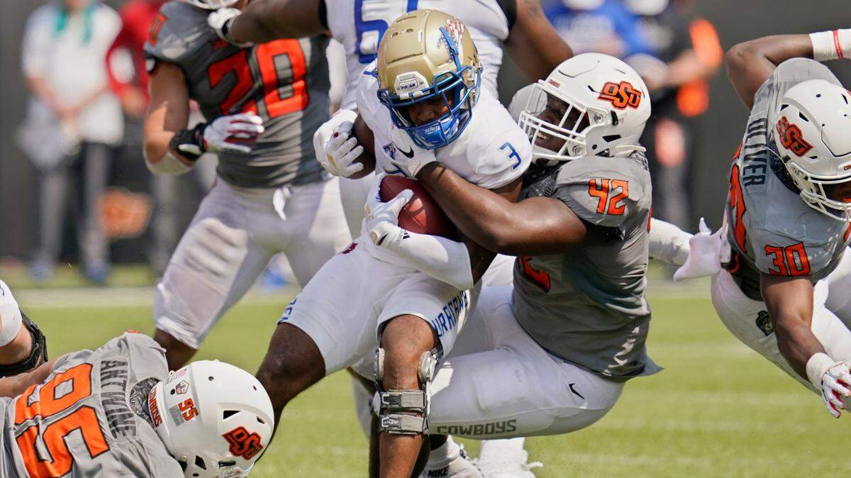 Tulsa running back Shamari Brooks (3) is tackled by Oklahoma State defensive tackle Jayden Jernigan (42) in the second half of an NCAA college football game, Saturday, Sept. 11, 2021, in Stillwater, Okla. (AP Photo/Sue Ogrocki)