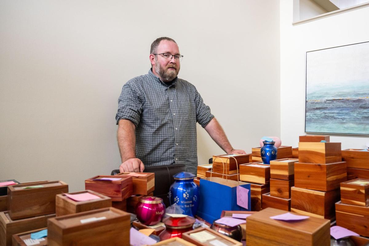 Jarrod Hammond, owner of Heartland Pet Aquamation, stands next to a table full of pet cremated remains in cedar boxes ready to be returned to their owners. Running out of space, the West Bottoms company is moving to a nearby locale.