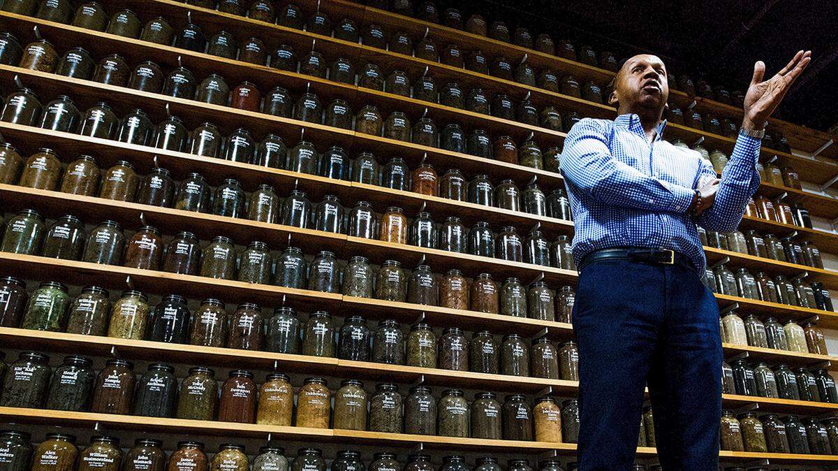 Bryan Stevenson, executive director of the Equal Justice Initiative, stands before jars containing soil from the sites of confirmed lynchings of Black people.