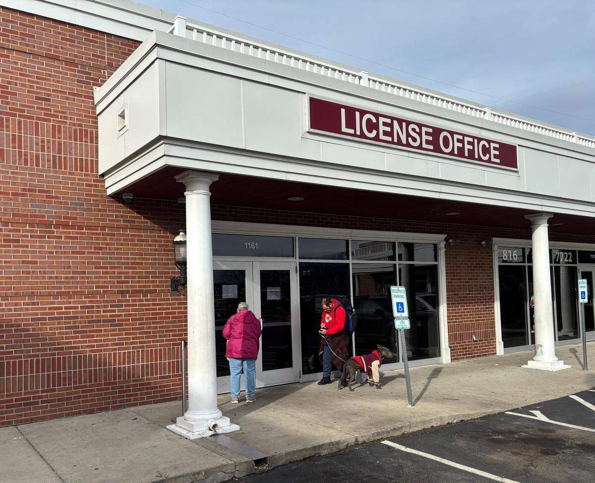 Two people stand outside the closed Kansas City DMV at 1161 Emanuel Cleaver II Blvd., on Jan. 13. This location, the only Kansas City DMV south of the river, is shuttered until further notice. 