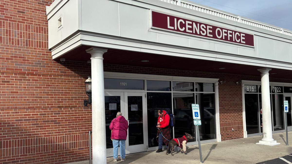 Two people stand outside of the closed Kansas City DMV at 1161 Emanuel Cleaver II Blvd. The location, the only Kansas City DMV south of the river, reopened after closing for 20 days. Jan. 13, 2026.