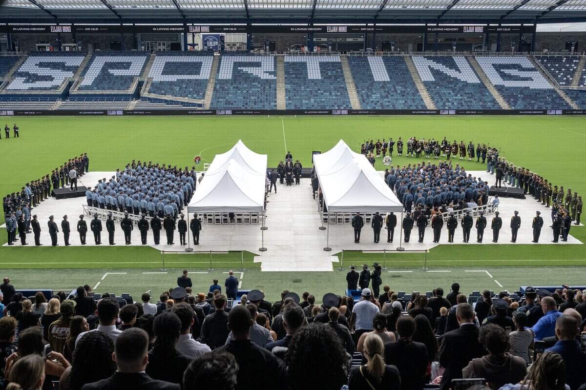 Attendees and first responders stand in respect as Deputy Elijah Ming's casket is carried out of Children's Mercy Park following the funeral service on Monday, Aug. 11, 2025, at Children's Mercy Park in Kansas City, Kansas.