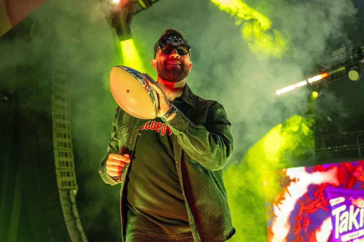 Kansas City Chiefs tight end Travis Kelce dances while handing out singed footballs during Kelce Jam at the Azura Amphitheater on Saturday, May 18, 2024, in Bonner Springs, Kansas.