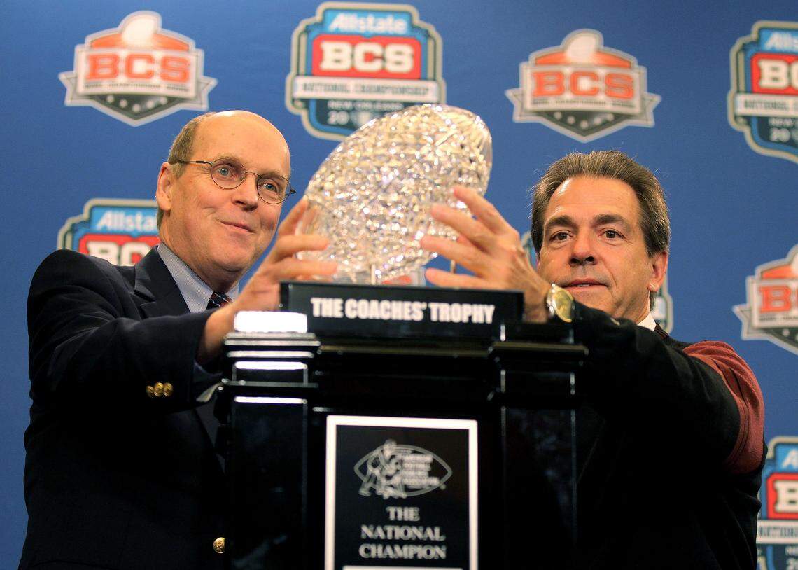Bowl Championship Series executive director Bill Hancock, left, and Alabama football coach Nick Saban hold The Coaches' Trophy after the Crimson Tide’s defeat of LSU for the national championship on Jan. 10, 2012 in New Orleans.
