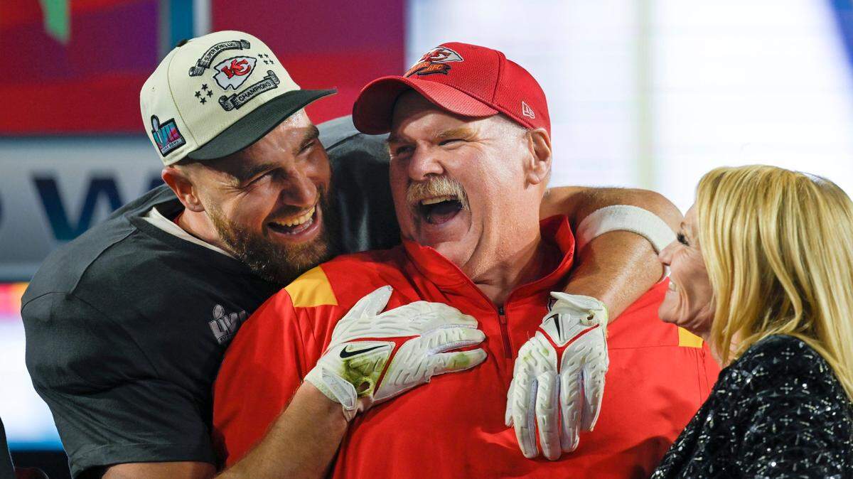 Kansas City Chiefs tight end Travis Kelce (87) hugs Chiefs Head Coach Andy Reid as Tammy Reid looks on after the Chiefs won Super Bowl LVII, defeating the the Philadelphia Eagles, 38-35, on Sunday, Feb. 12, 2023, at State Farm Stadium in Glendale, Arizona.
