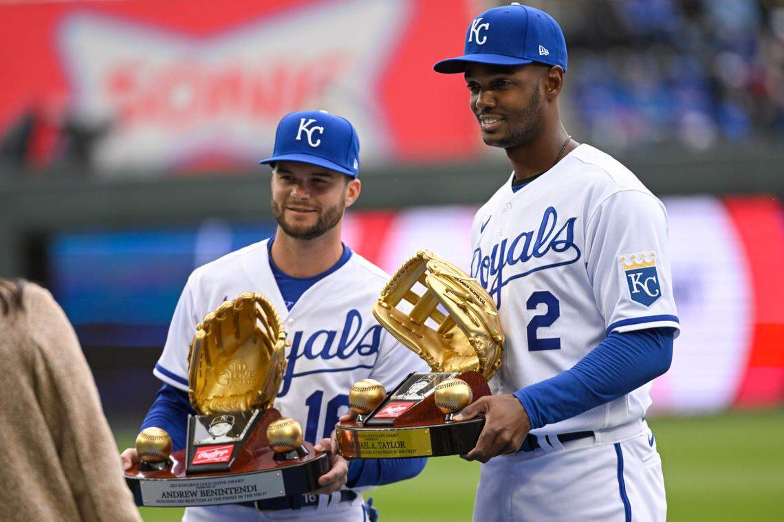Kansas City Royals left fielder Andrew Benintendi (16) and Royals center fielder Michael A. Taylor (2) pose with their Gold Glove awards before the start of a baseball game against the Cleveland Guardians Thursday, April 7, 2022 in Kansas City, Mo. (AP Photo/Reed Hoffmann)