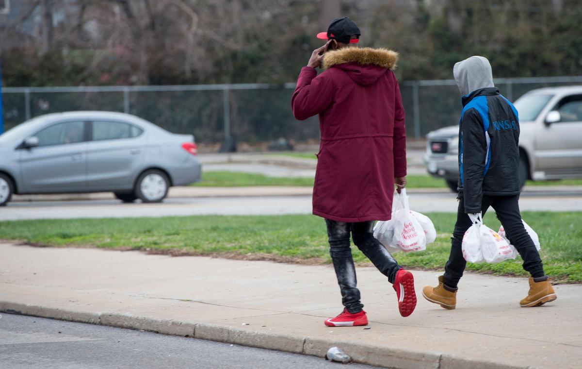 Students carried sack meals as they walked away from Central High School on Tuesday, March 24, 2020. Kansas City Public Schools food service workers have made roughly 7,500 meals a day to feed thousands of kids amid COVID-19 school closure.