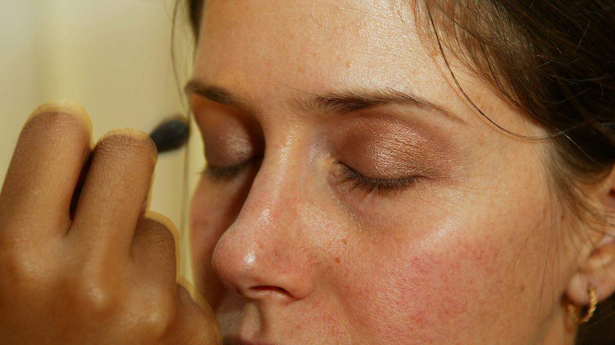 A woman getting her makeuo done.
