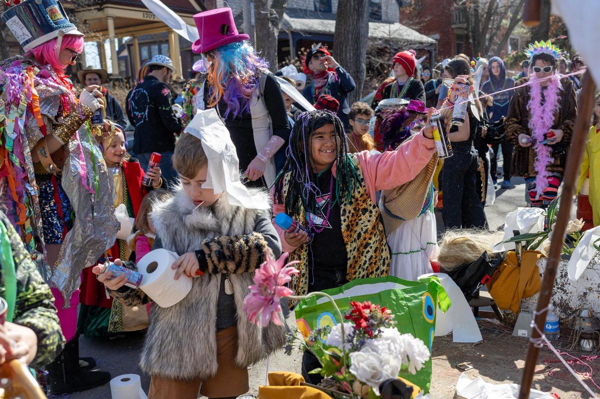 Children use silly string, toilet paper and confetti to cover Maximón, the patron saint of bad behavior, during the Krewe de Prank parade on Sunday, March 2, 2025, in Kansas City.