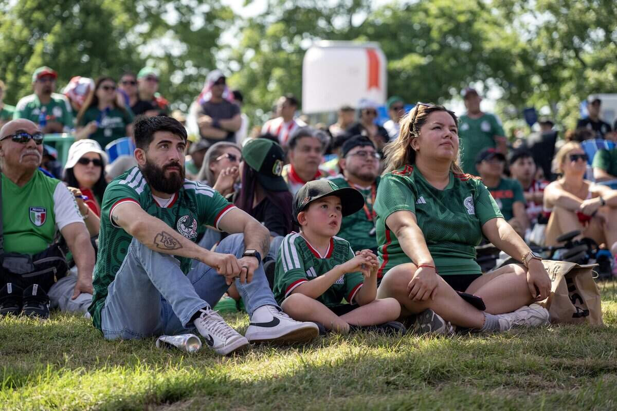 Anthony Arzola, left, his son Anthony and wife Ana lounge on the grass while watching a FIFA World Cup match between Mexico and South Africa under the live plus canopy at the FIFA Fan Festival on Thursday, June 11, 2026, in Kansas City.
