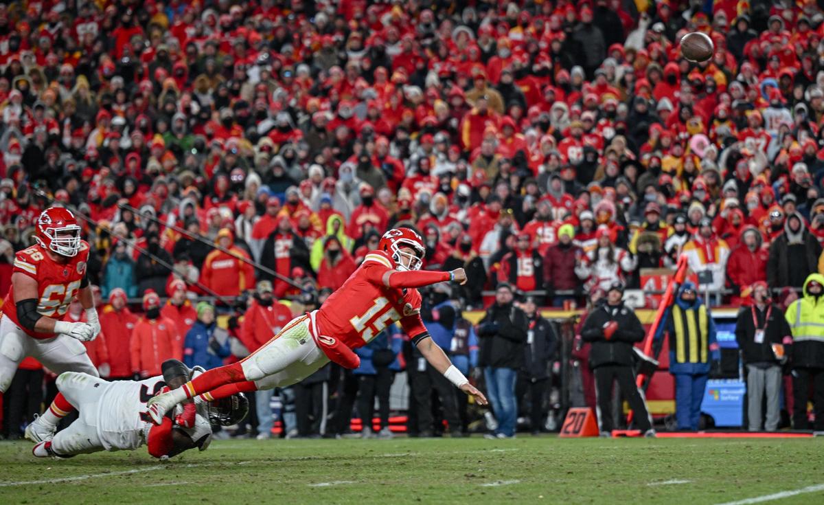 Kansas City Chiefs’ Patrick Mahomes (15) goes down in the grasp of Houston Texans defensive tackle Mario Edwards Jr. while he throws a touchdown pass to tight end Travis Kelce in the fourth quarter during the AFC Divisional Round playoff game on Saturday, Jan. 18, 2025, at GEHA Field at Arrowhead Stadium.