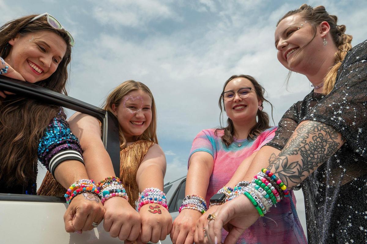 Eva Stigler, left, Rachel Stigler, Nicole Burks and Katie Welker show off their friendship bracelets while waiting in line at Taylor Swift’s Eras Tour stop at GEHA Field at Arrowhead Stadium on Friday, July 7, 2023, in Kansas City.