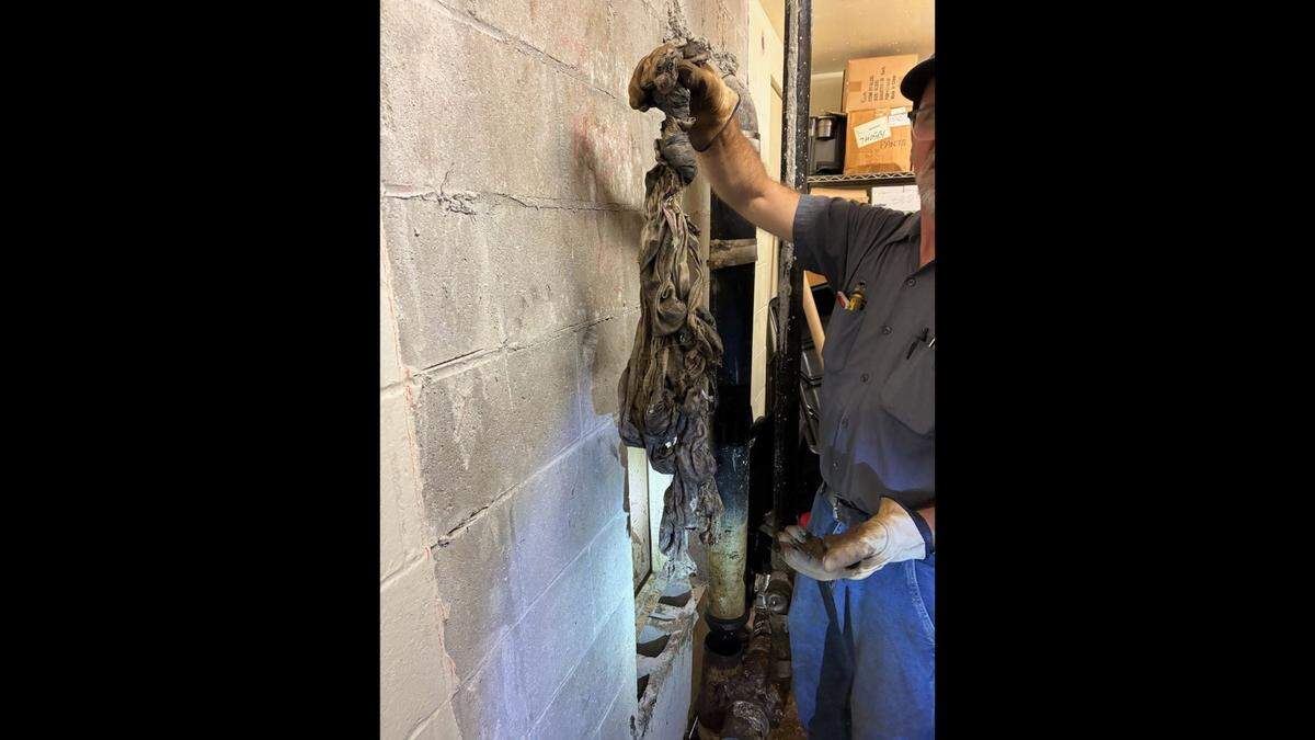 A Clay County facilities worker holds up a bundle of cloth found in a pipe at the Clay County Detention Center. A recent sewage leak, allegedly caused by inmates clogging toilets at the Clay County jail, has forced some office personnel to relocate.