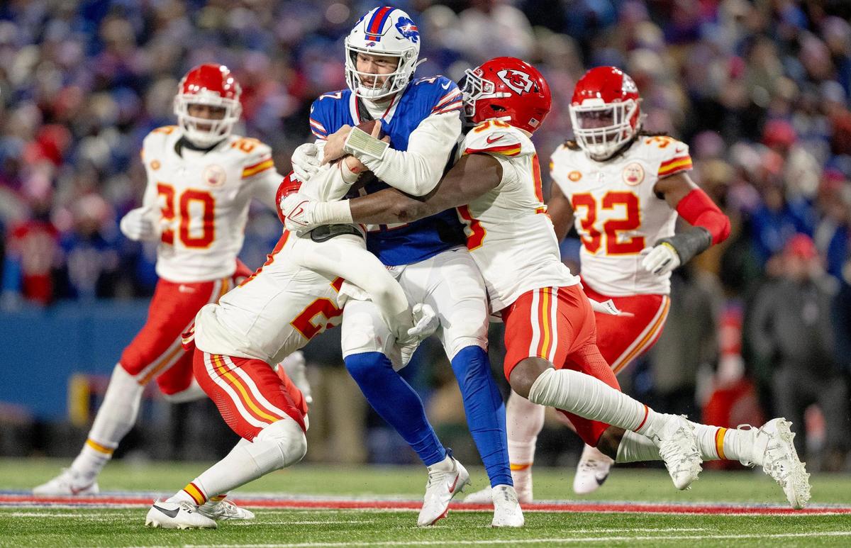 Kansas City Chiefs safety Chamarri Conner (27) and defensive end Charles Omenihu (90) tackle Buffalo Bills quarterback Josh Allen (17) during an AFC Divisional Round playoff game at Highmark Stadium on Sunday, Jan. 21, 2024, in Orchard Park, New York.