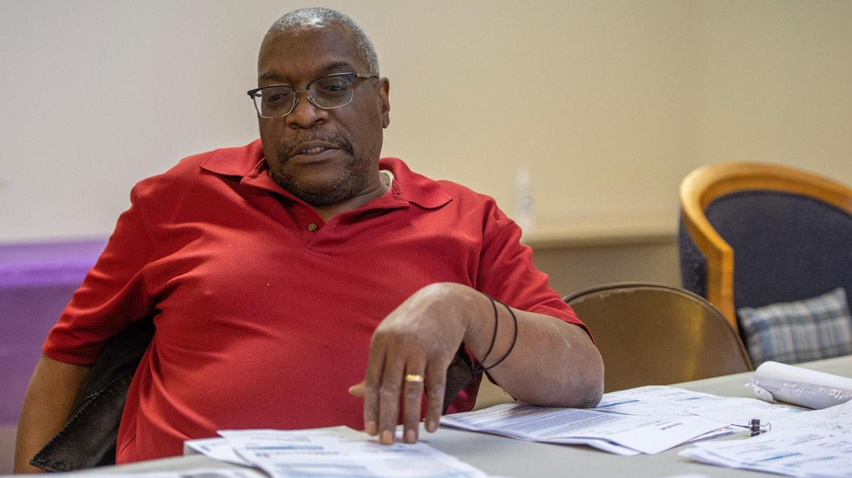 Ronald Carter shows a variety of water bills at Linwood United Church on Friday, Feb. 10, 2023, in Kansas City. Carter discussed the high water bill the church recently had to pay despite there being no water leaks or increases in water usage in the building.