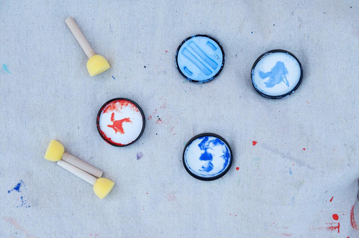 Brushes and paint caps sit on a blanket on Friday, Sept. 15, 2023, at the Riverfront Heritage Trail in Kansas City. Murals are painted underneath the Town of Kansas Bridge and range from 14 feet to 42 feet in length.