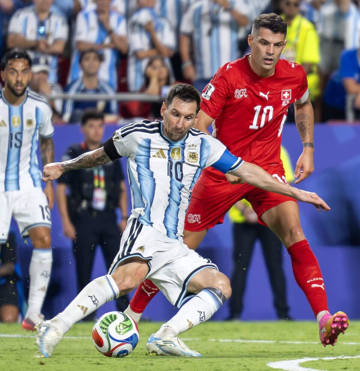 Argentina forward Lionel Messi (10) shields the ball from Switzerland midfielder Granit Xhaka (10) before passing during extra time of the FIFA World Cup quarterfinal against Switzerland at Kansas City (Arrowhead) Stadium on Saturday, July 11, 2026.