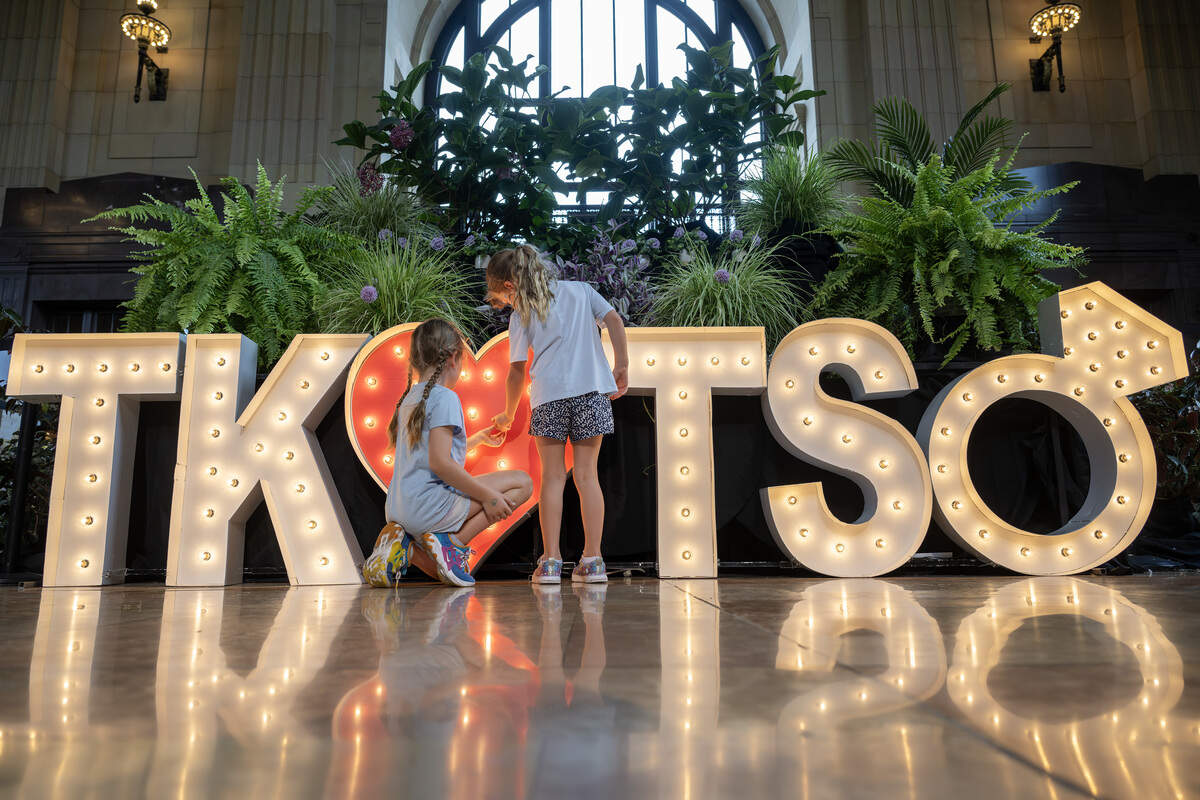 Eight-year-old Solveig Wagner, left, and her six-year-old sister, Brindis Wagner, tighten a loose bulb on a lighted display celebrating Taylor Swift and Travis Kelce’s engagement on Sunday, Aug. 31, 2025, at Union Station in Kansas City.