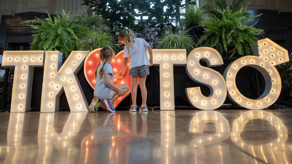 Eight-year-old Solveig Wagner, left, and her six-year-old sister, Brindis Wagner, tighten a loose bulb on a lighted display celebrating Taylor Swift and Travis Kelce’s engagement on Sunday, Aug. 31, 2025, at Union Station in Kansas City.