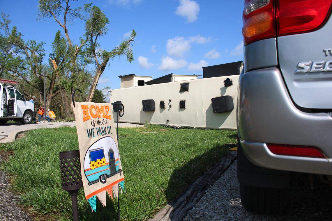 A flag that reads “home is where we park it,” is seen in front of an RV that was overturned during a tornado at Shady Acres RV Park in Hillsdale, Kansas Tuesday.