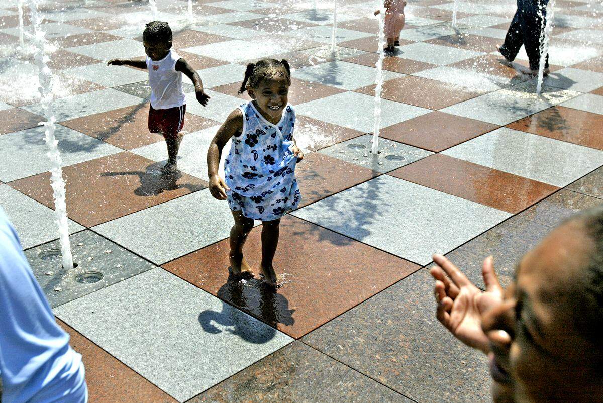 PARKER ESHELMAN/ The Kansas City Star Destiny, left, and Grace Johnson play in the Crown Center fountains, as their mom, Natisha gets a good laugh. cutline: Destiny (left) and Grace Johnson played in the fountains at Crown Center on a recent Sunday afternoon.