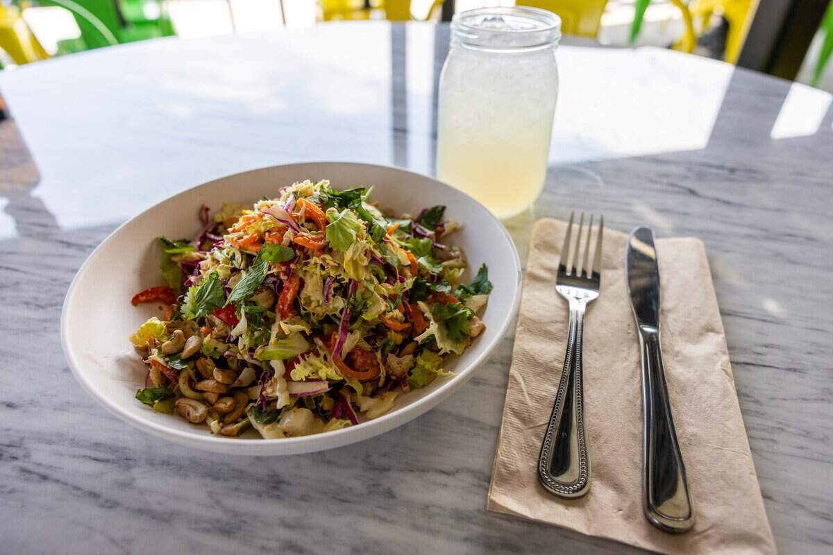 A ginger miso crunch salad and rose petal lemonade are served at the new Flower Child restaurant in Prairie Village on Friday, Aug. 7, 2026. The salad is vegan and gluten-free.