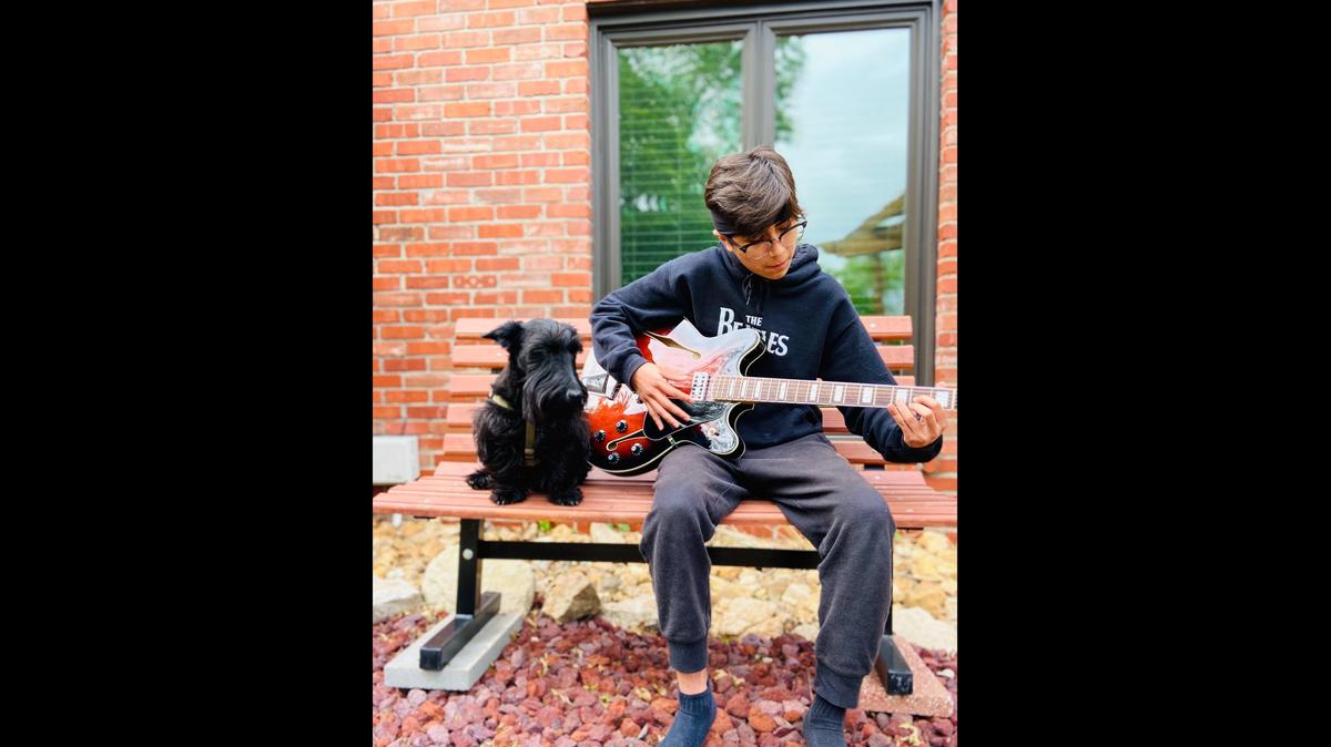 Luis Pecina, 13, plays guitar outside his Kansas city home on May 12, 2020, beside his dog, Luna. The eighth grader at Kansas City’s Foreign Language Academy is spending his free time during the coronavirus lockdown playing music and making TikToks.