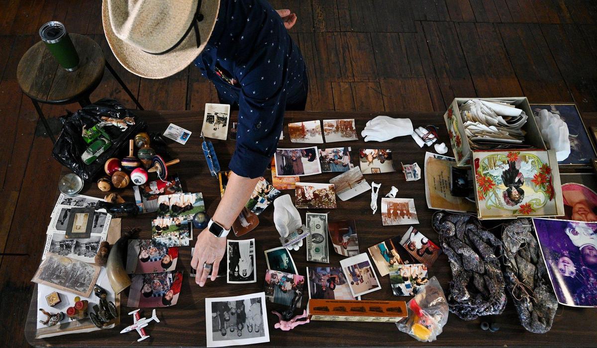 Israel Alejandro Garcia Garcia works on his multimedia installation for the new airport terminal titled “Diaspora No. 1” Tuesday, April 19, 2022. In the photos and items laid out on the table in his Crossroads district studio, Garcia said he looks for parallels between different peoples’ cultural experiences. The work will also contain a video element.