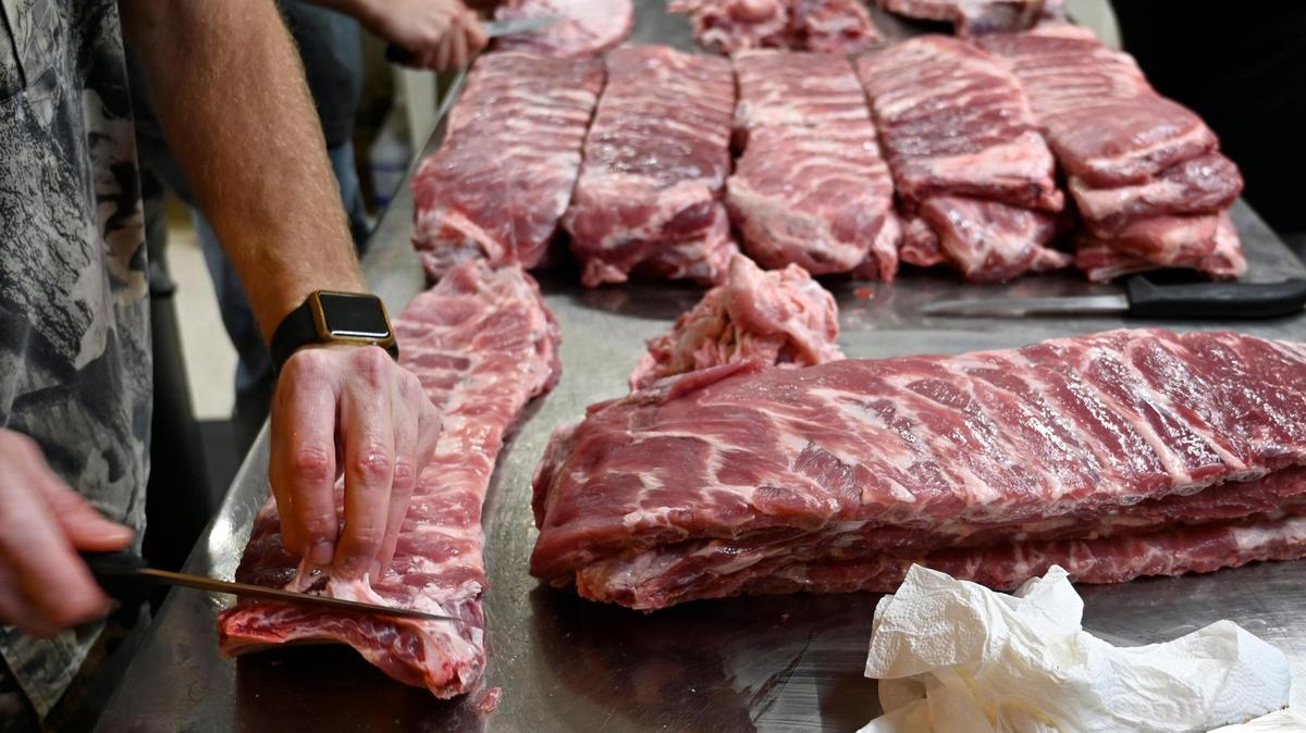 Slabs of pork ribs are trimmed by hand before being seasoned and smoked at Guy & Mae’s Tavern in Williamsburg, Kansas.