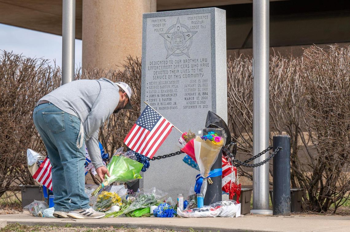 Paul Nou, of Grain Valley, places flowers at the Independence Police Department memorial for fallen officers for police officer Cody Allen on Friday, March 1, 2024, in Independence. Officer Allen along with Jackson County civil process server Drexel Mack were both shot and killed Thursday after Mack attempted to serve an eviction notice.