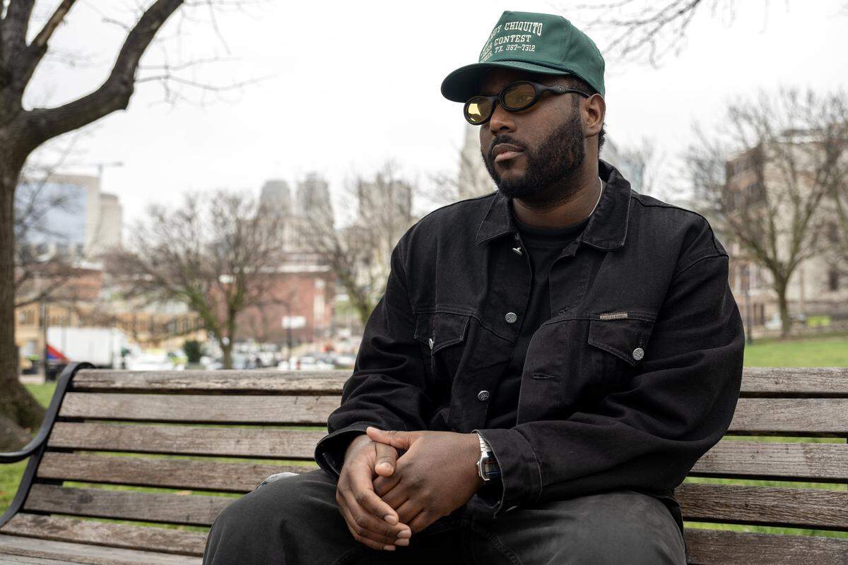 Casio McCombs sits on a park bench for a portrait near the River Market on Wednesday, April 1, 2026, in Kansas City. McCombs is the creator of Sundown HiFi, a planned lounge at Current Landing that was canceled following backlash over its name.