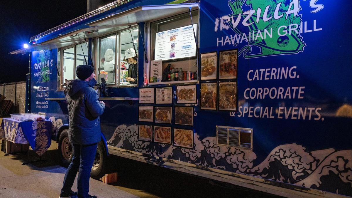 A customer orders from Irvzilla’s Hawaiian Grill food truck.