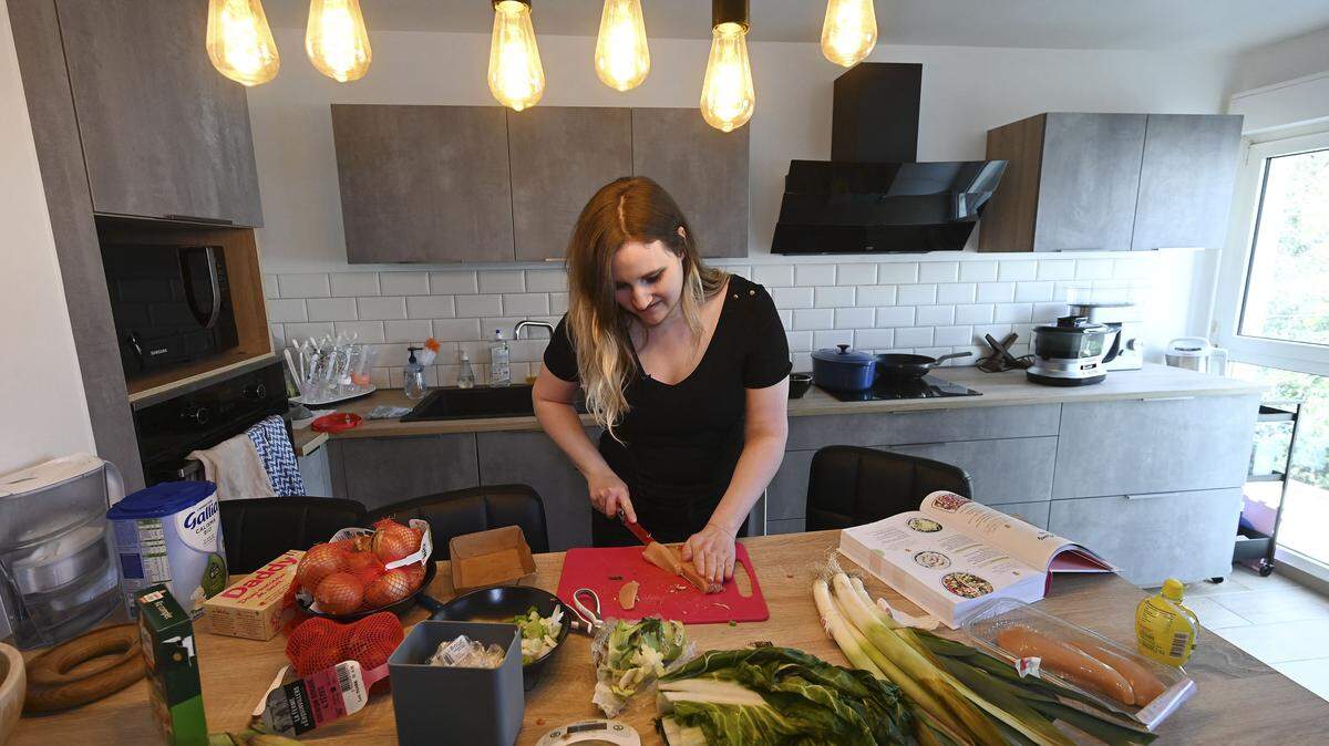 A woman prepares food in her kitchen. (Photo by Frederick FLORIN / AFP) (Photo by FREDERICK FLORIN/AFP via Getty Images)