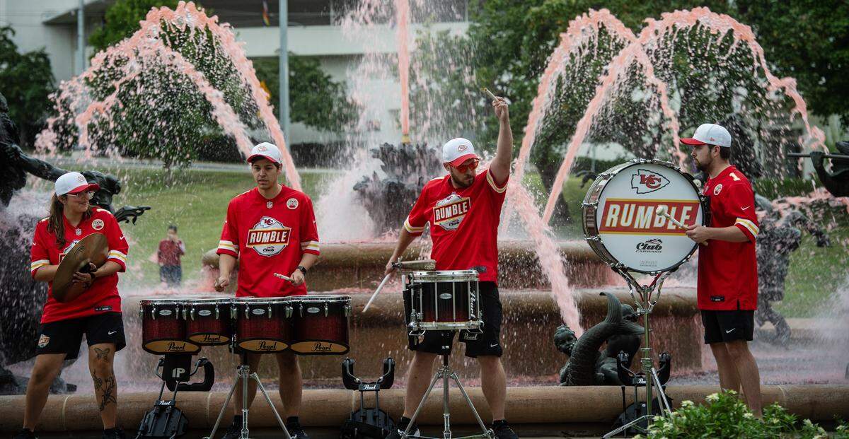 Members of the Rumble drum ensemble perform after the fountain at Mill Creek Park was dyed red to celebrate Red Friday on Friday, Sept. 5, 2024, in Kansas City.