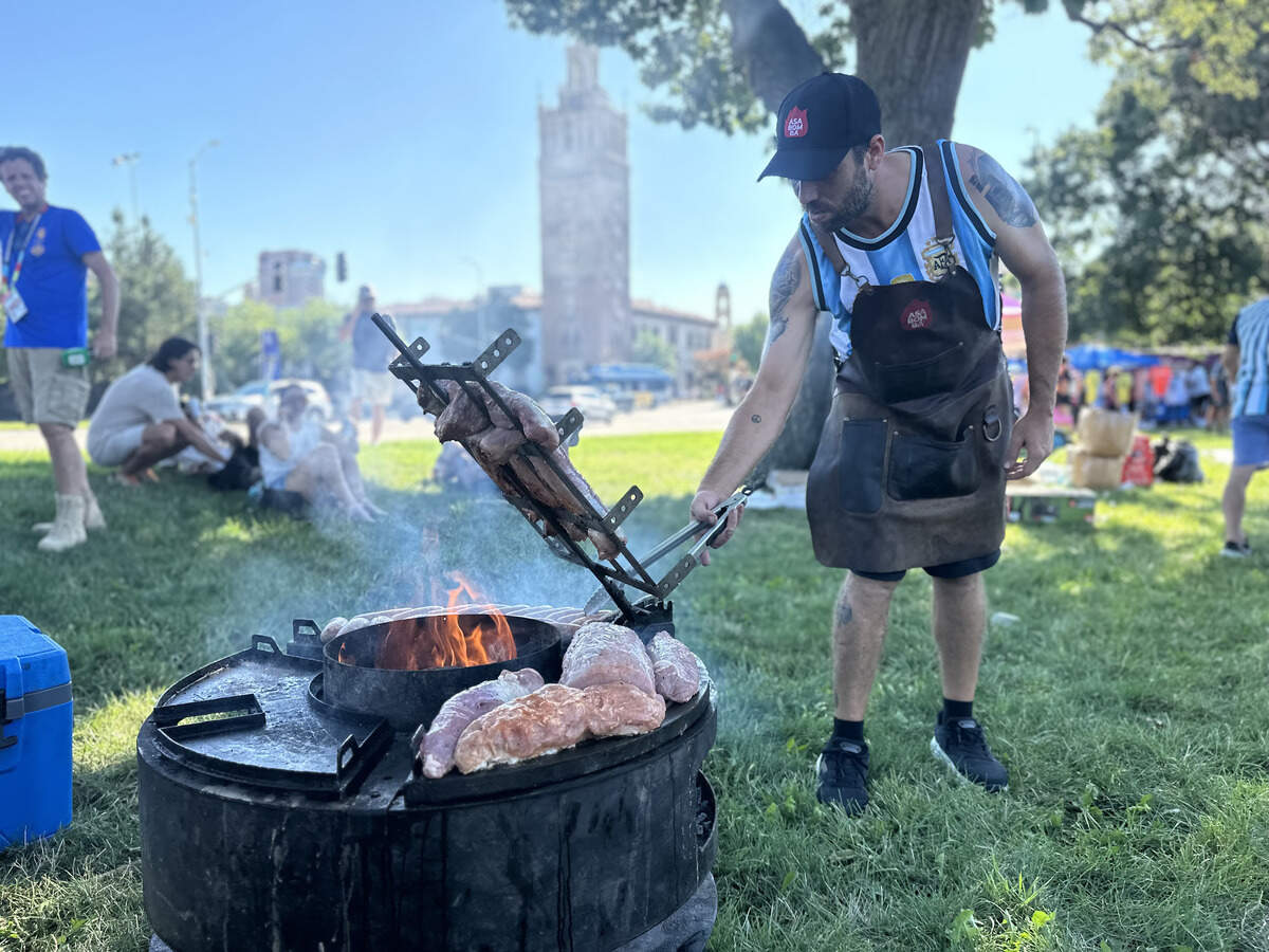Santiago Alberdi grills meat at the Argentinian pre-match pep rally on July 10, 2026. Alberdi has traveled the country with his grill to cook meat outside of each match.