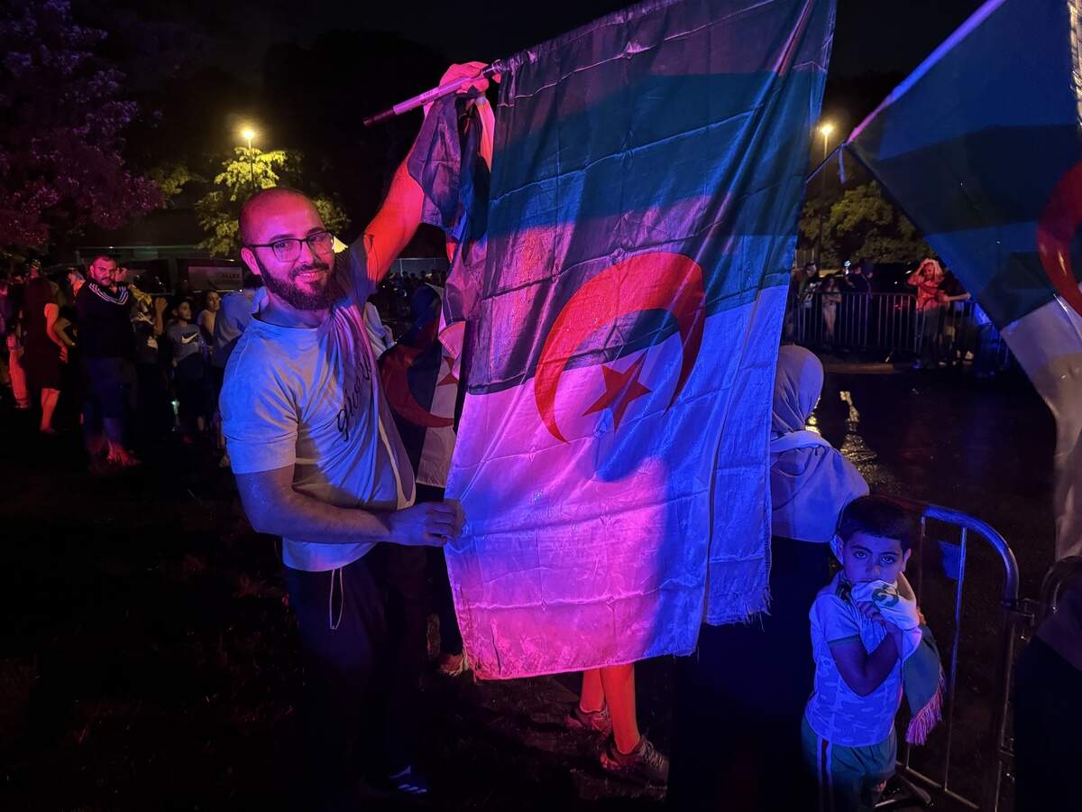 A fan of Algeria’s national soccer team held up an Algerian flag Sunday as he awaited the arrival of the squad at Lawrence’s DoubleTree by Hilton Hotel on Sunday, June 7, 2026.