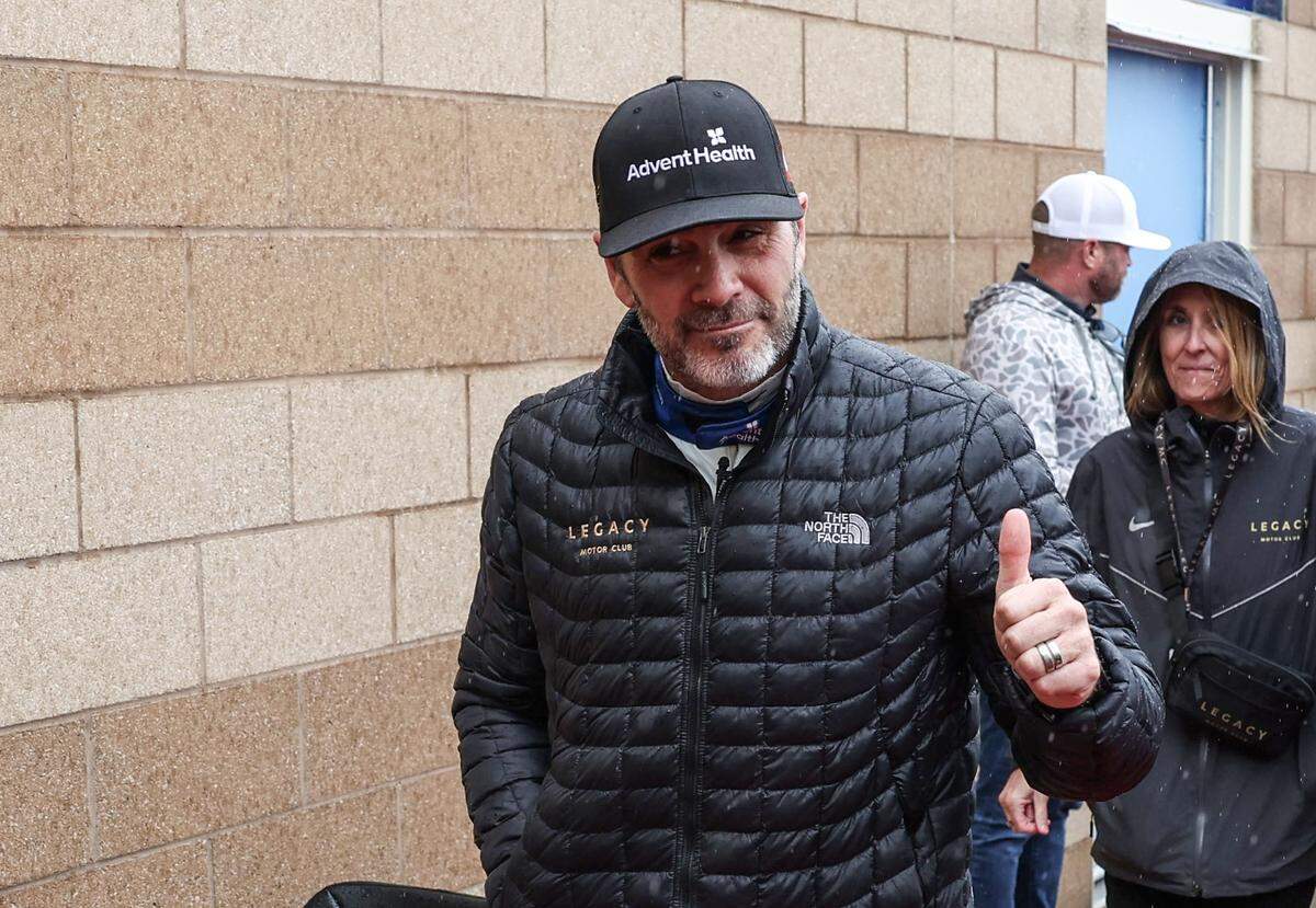 NASCAR Cup Series driver Jimmie Johnson gives a thumbs up to fans during a pre-race rain delay at Kansas Speedway on Sunday.