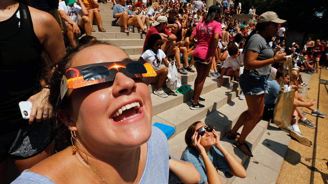 Anna Neighbors views the eclipse in front of the Amelia Gayle Gorgas Library on the Quad at the University of Alabama Monday, August 21, 2017. [Staff Photo/Gary Cosby Jr.]