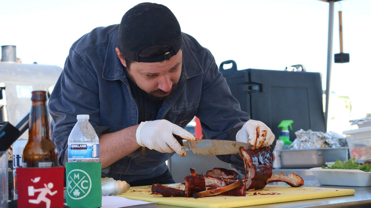 Shorthorn BBQ’s Michael Lunsford, an Olathe resident, slices his pork ribs before submitting them for judging at the Qlathe BBQ Championship.