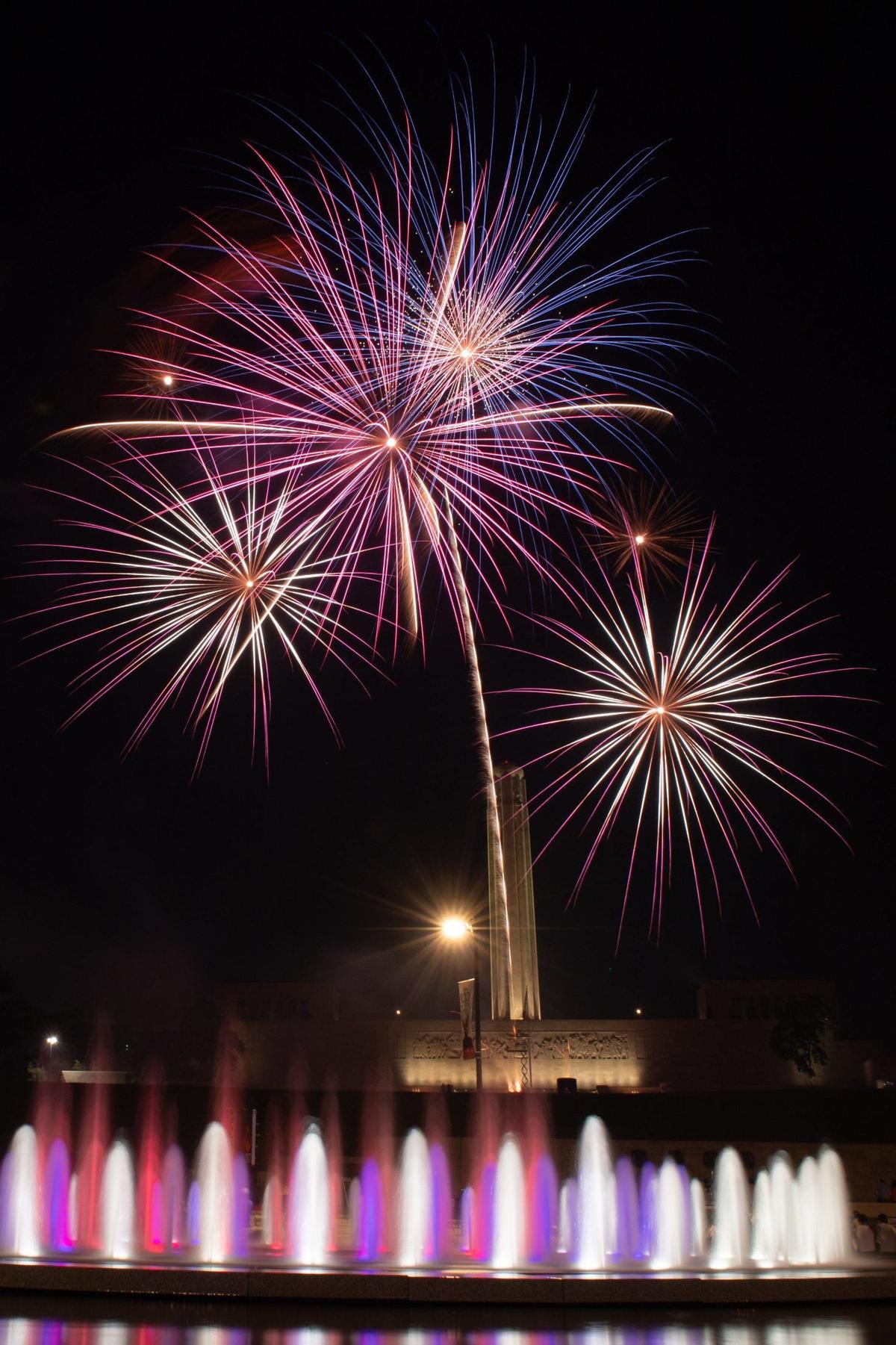 Fireworks burst over the tower at the National WWI Museum and Memorial and the Henry Wollman Bloch Fountain Thursday in Kansas City.