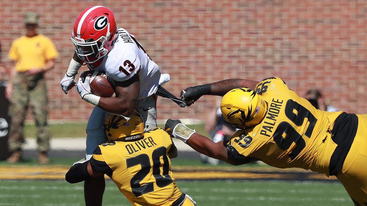 Missouri defenders Khalil Oliver and Walter Palmore stopped Georgia running back Elijah Holyfield on a play in the second half on Saturday in Columbia.