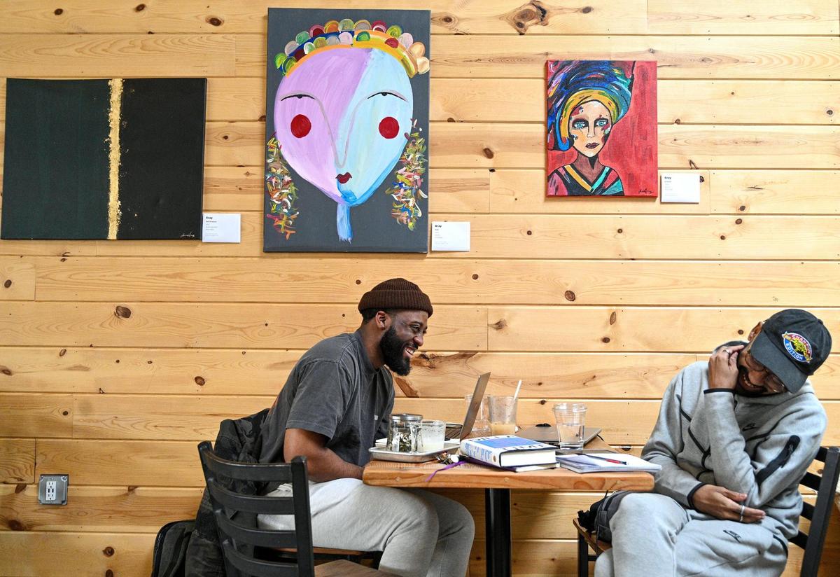 One of the ways Muenfua Lewis of Kansas City describes Black joy is being a Black creative who can work and create in cool spaces. Lewis, left, a brand strategist for a company in New York, and his friend Jeremy Yon, a compliance professional, share a light moment as they worked at Rochester Brewing and Roasting Company in the Crossroads Tuesday, Feb, 15, 2022. Lewis also said that investing in Black joy is investing in Black futures.