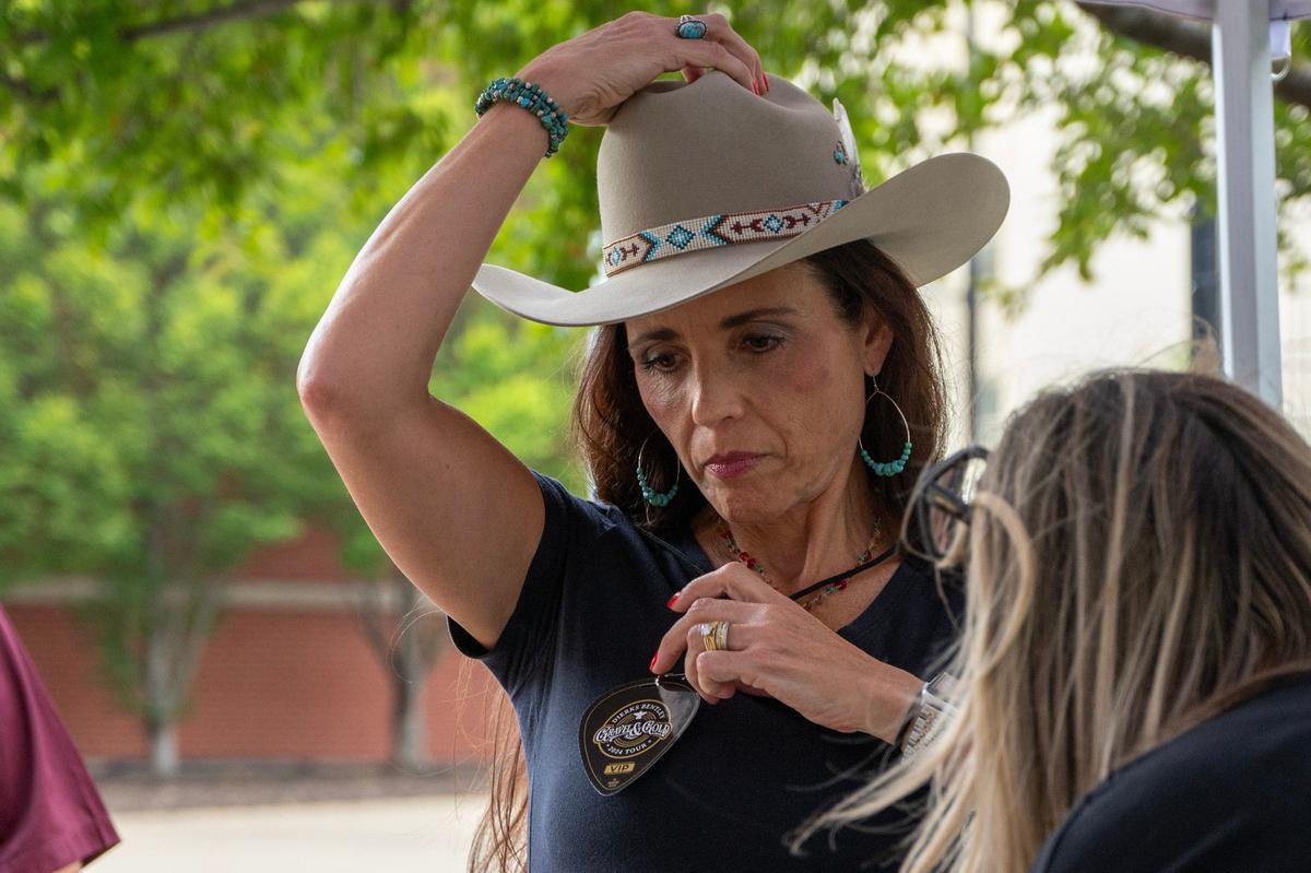 Karen Johnson puts on her pass at the VIP tent outside T-Mobile Center before the Dierks Bentley concert on Friday, Aug. 23, 2024, in Kansas City.