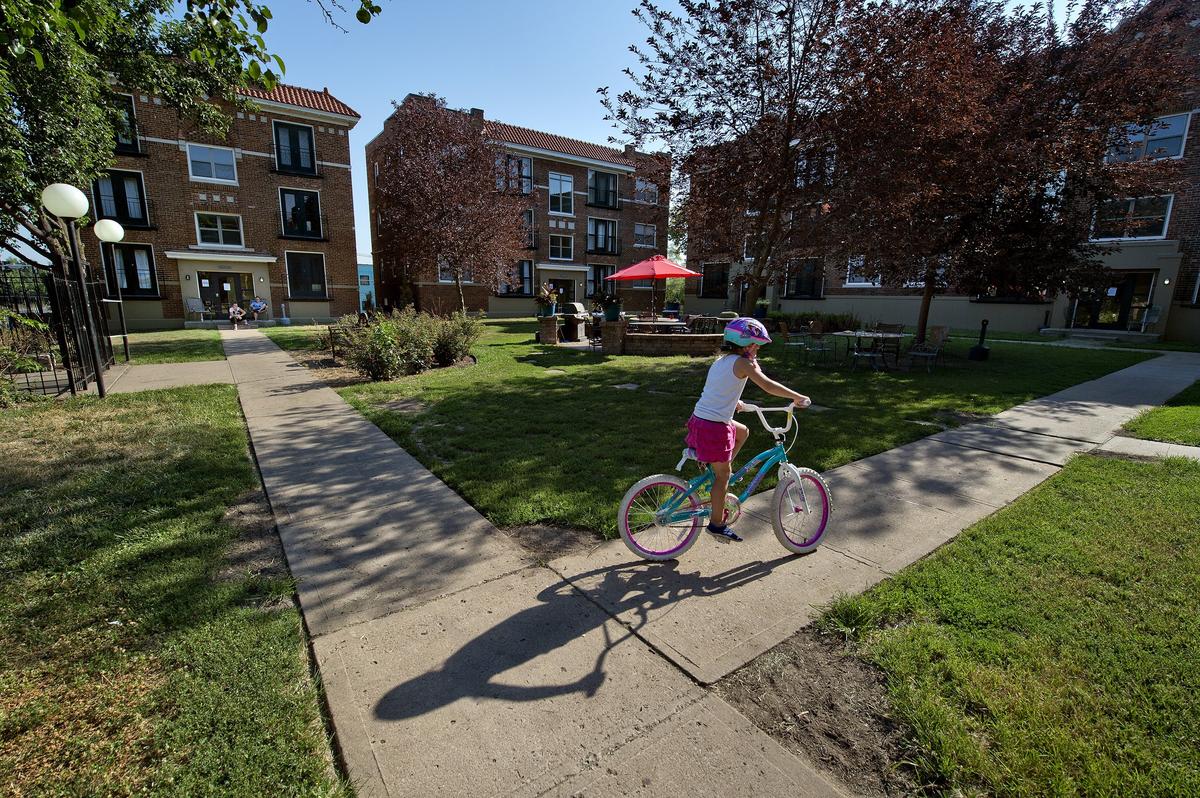 Seven-year-old Athenia Smith rides her bike around the central courtyard at Amethyst Place, 2735A Troost Ave. She and her mother have lived for two months at Amethyst Place, which provides recovery housing for women and their children.