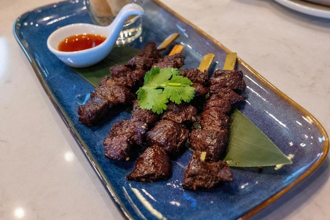 Barbecue and sticky rice rolls, featuring marinated medium-rare ribeye on a skewer, served with fried sticky rice rolls, and house-made sauce are served at Penny’s in The Village on Thursday, Jan. 9, 2025, in Prairie Village.