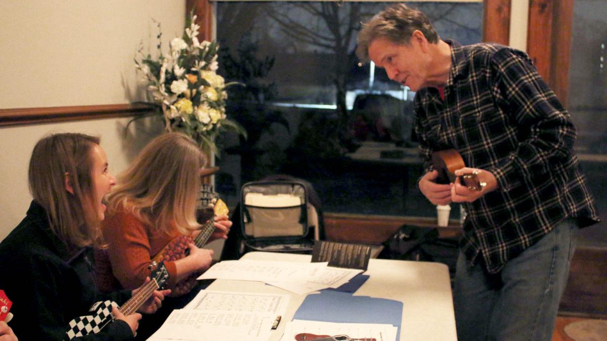 Jill McAtee and Ronda Van Quaethem, both of Overland Park, get some laughs and musical tips from teacher David Firman during a ukulele class at Shawnee Town.