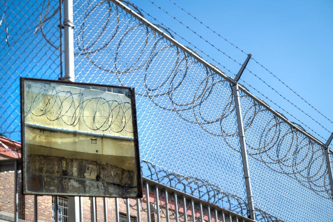 Razor wire is reflected in a mirror at the former checkpoint for motor vehicles at the Lansing Correctional Facility.