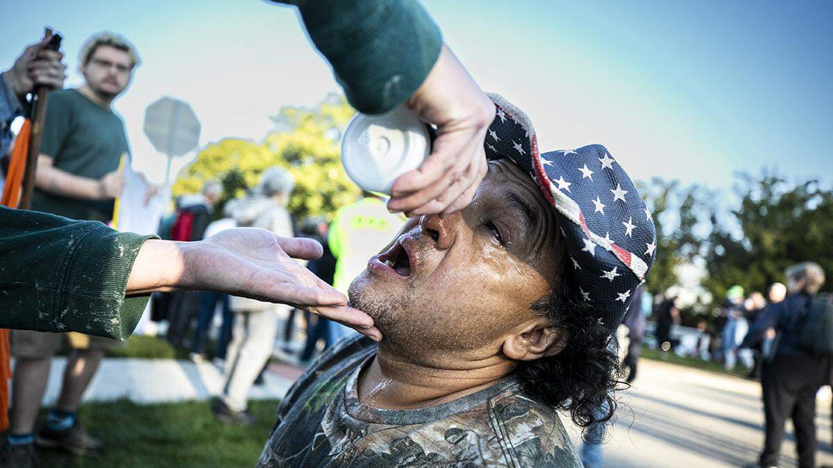 A protester is helped after inhaling tear gas outside a U.S. Immigration and Customs Enforcement facility in the western suburbs of Chicago.